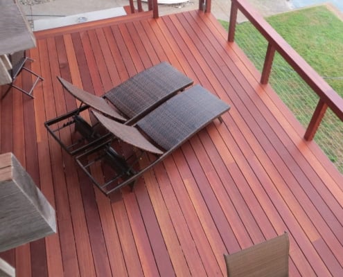 Batu-Deck-from-above A batu deck viewed from above. There is a cable railing framed with tigerwood surrounding it. Both the deck and railing have been stained a deep-red. The batu 4x4 have been drilled for the cable rail.