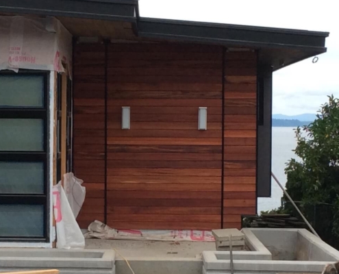 tigerwood-Siding-tongue-and-groove tigerwood tongue and groove siding installed on a home under construction overlooking Puget sound.
