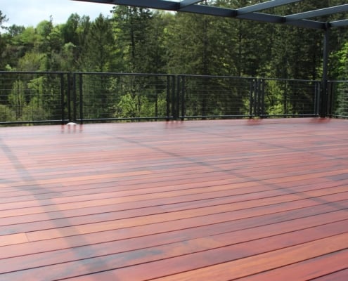 Tiger-Deck-in-McMinville-OR A very modern tigerwood deck with a metal and hogwire railing. The deck has a structural steel pergola above it.