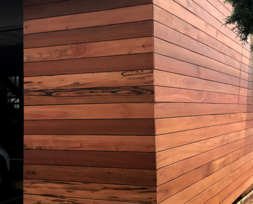 Tigerwood-open-joint-cladding-hardwood-siding A modern design home with tigerwood open-joint cladding. The whole front of the garage is covered in the siding.