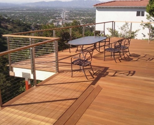 Golden-Yellow-Balau-Deck-with stainless-steel-cable-rail A deck overlooks a suburban desert landscape. The deck is yellow balau, the grain is straight and knot-free. An all stainless steel cable rail surrounds it. The rail is capped with yellow balau 2x4 as well.