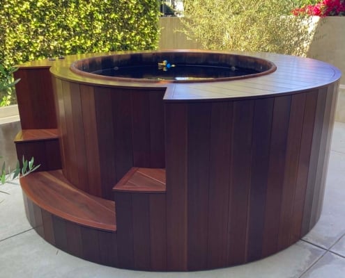 Hot-tub-wrapped-with-South-Pacific-Redwood-Manilkara-Torem-side-view A hot tub enclosure wrapped in the dark red tropical hardwood Torem. The Torem lumber is finished in Natural tone Exxoshield stain.