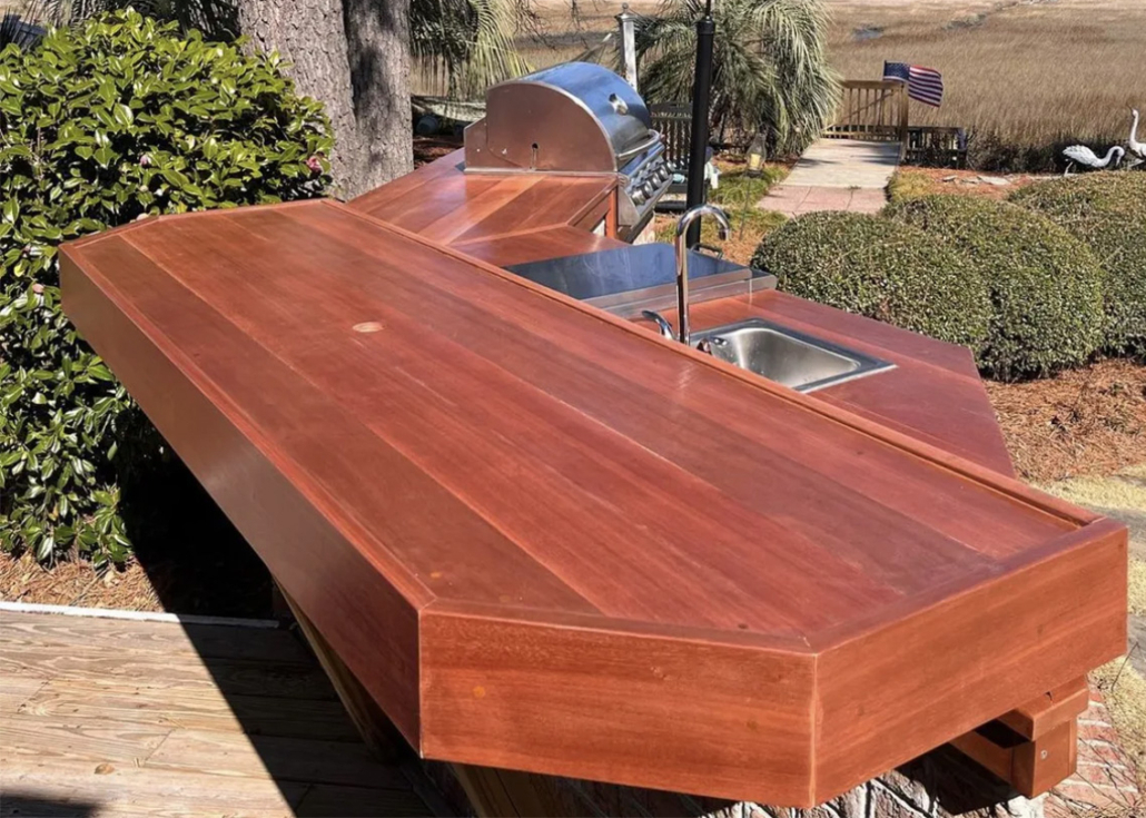 torem-bench A bench made from south pacific redwood sits above an outdoor kitchen and barbeque also made from torem.